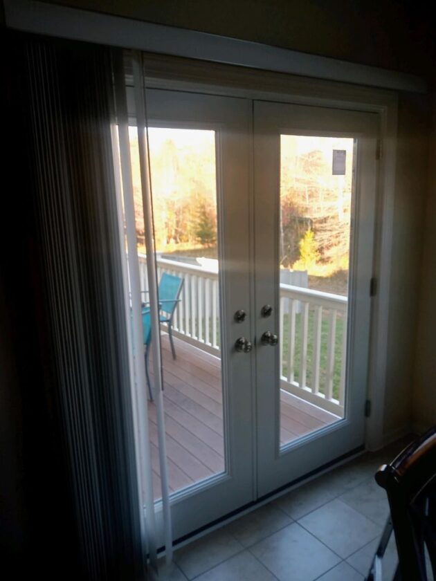 Interior view of a home with new white French doors leading to a deck with a blue chair