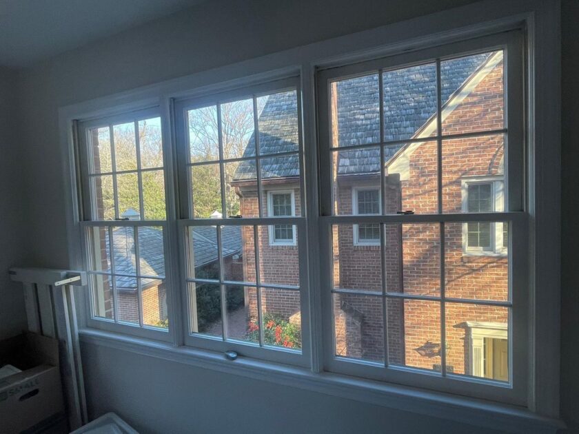 Interior view of a new white window installation with a suburban neighborhood visible outside